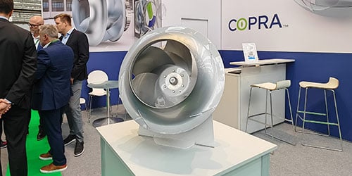 COPRA fan on display at a trade show with people in the background.